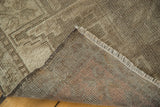 Detail of the hand-knotted foundation and distressed neutral pile of a vintage Oushak rug.