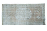 Distressed Oushak rug with faded dusty rose field, muted grey tones, and visible foundation texture.
