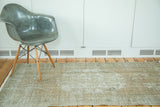 Distressed Oushak rug revealing muted dusty rose and grey tones with low pile texture.