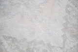 Distressed Oushak runner with faded curvilinear motifs, displaying soft apricot and ivory texture.
