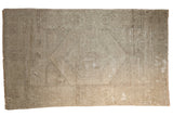 Vintage distressed Oushak rug featuring a subtle medallion and neutral pale grey tones.