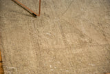Muted neutral tones and textured surface of a distressed hand knotted Oushak rug.