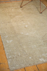 Distressed Oushak rug surface showing textural wear and pale neutral tones.