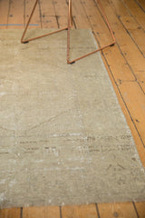 Distressed vintage Oushak rug showcasing its textured pale grey pile and worn edge.