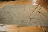Distressed Oushak rug with pale grey field, neutral medallion, styled with modern copper table.