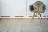 Faded beige Oushak rug with distressed texture and subtle rectilinear weaving.
