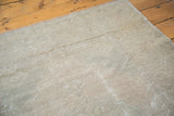 Textured surface of distressed Oushak rug, showcasing beige and silver analogous tones.