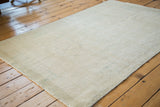Distressed Oushak rug close-up showing subtle faded beige and calm aqua texture.