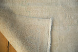 Hand knotted foundation, fringe, and distressed light-tone pile of the Oushak rug.