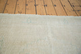 Distressed Oushak rug pile showcasing faded beige, platinum, and calm aqua details.