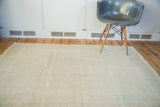 Faded distressed vintage Oushak rug showcasing subtle beige and calm aqua tones.