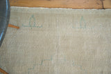 Distressed Oushak rug pile, faded light beige and platinum with subtle aqua blue motifs.