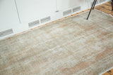 Vintage distressed Oushak rug with worn pile, faded dusty rose, and silver tones.