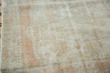 Distressed Turkish Oushak rug pile, featuring faded rose hues and soft beige.