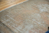 Distressed Oushak runner pile, showing faded apricot, grey, and woody tones.