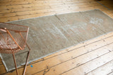 Distressed Oushak runner featuring geometric patterns in faded apricot, grey, and woody tones.