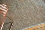 Distressed Oushak runner texture with faded apricot, grey, and wooded tones.