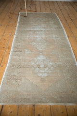 Distressed Oushak runner showcasing faded apricot and grey, with geometric tribal motifs.