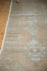 Distressed Oushak runner pile with faded apricot, grey tones and geometric leaf motif.