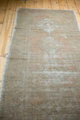 Distressed pile showing faded apricot, grey, and light wooded tones on the Oushak runner.