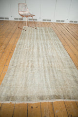 Distressed Oushak runner end with short fringe and visible foundation weave texture.