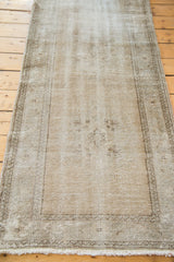 Distressed hand-knotted Oushak rug texture, showing faded light white and pewter tones.