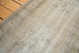Distressed Oushak rug with a close-up texture, featuring subtle faded apricot and platinum tones.