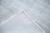 Hand-knotted foundation and distressed ivory texture of the vintage Oushak rug.