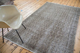Distressed vintage Turkish Oushak carpet with faded grey, charcoal, and deep green allover design.