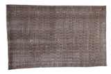 Heavily distressed Oushak carpet featuring a faded allover design in grey, charcoal, and green, 4'10