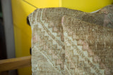 Subtle pink and ivory geometric pattern on a hand-knotted vintage Turkish Oushak rug pillow.
