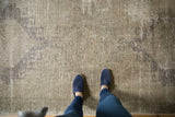 Distressed Oushak rug surface with faded medallion patterns and soft ivory, beige tones.