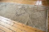 Distressed Oushak runner with hand-knotted texture in soft ivory and beige.