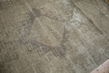 Close-up of a distressed Turkish Oushak runner with muted ivory, beige, and coffee bronze patterns.