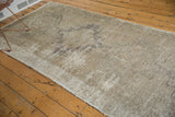 Distressed vintage Oushak runner's textured pile, with ivory, beige, and coffee bronze.