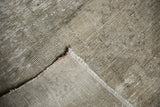 Close-up of distressed pile and hand-knotted foundation on vintage Oushak rug corner.
