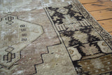 Detail of distressed Oushak rug showing geometric patterns, wide border, and recessed foundation.