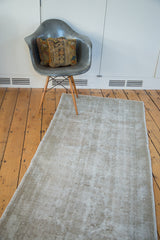Faded pattern and exposed foundation texture on a distressed Oushak rug in silver-grey tones.
