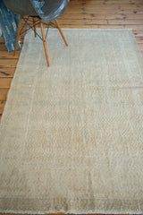 Distressed Oushak rug's short fringed edge with faded apricot and platinum tones.