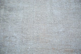 Receded grey wool pile reveals an embossed texture with subtle rose tones.