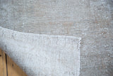 Distressed grey Oushak rug's embossed pile texture and hand knotted woven backing.
