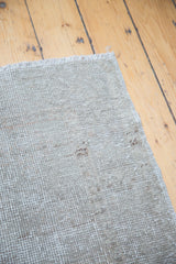 Hand-knotted foundation of the distressed Oushak rug with natural beige and grey weave.