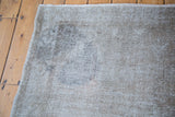 Distressed Oushak rug close-up, revealing recession to wool and an embossed grey texture.