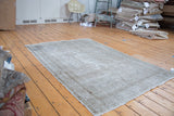 Vintage Oushak rug showcasing distressed character, neutral grey tones, and embossed texture.