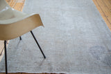 Distressed hand-knotted Oushak rug displaying textured grey tones and recessed pile.