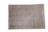 Distressed hand-knotted Turkish Oushak rug in muted grey and rose tones.