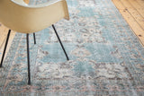 Distressed vintage Oushak rug with faded teal, ivory, and brown textured patterns.
