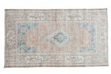 Distressed Oushak rug with peach apricot medallion, aqua spandrels, oversized cartouche border.