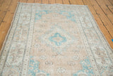 Distressed Oushak rug detail: faded peach apricot field with aqua spandrels and border cartouches.