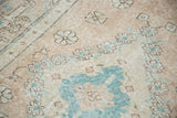 Peach apricot field and aqua green spandrel motif on distressed Oushak rug.